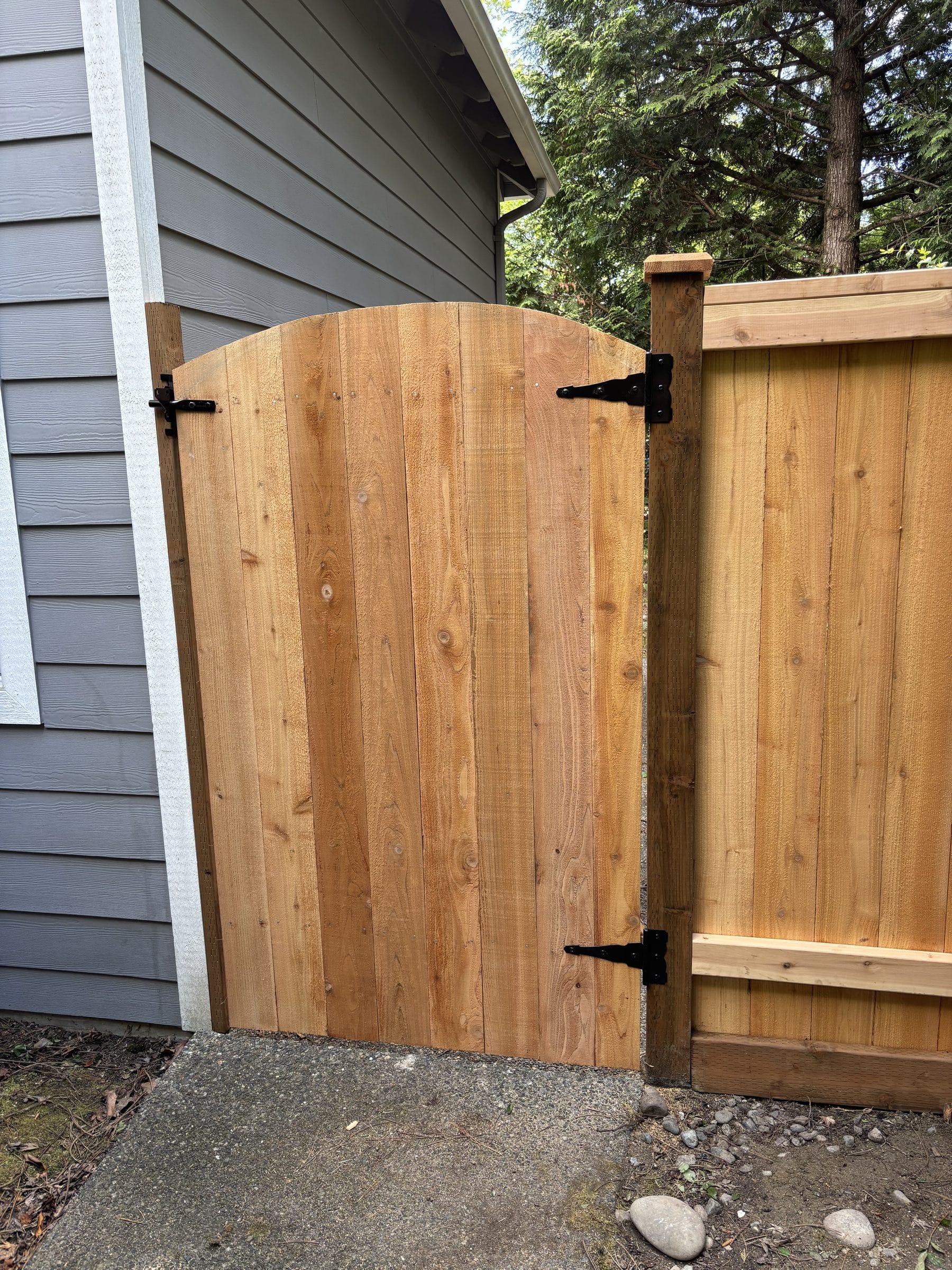 Arched cedar privacy gate with black hardware in Kirkland Washington