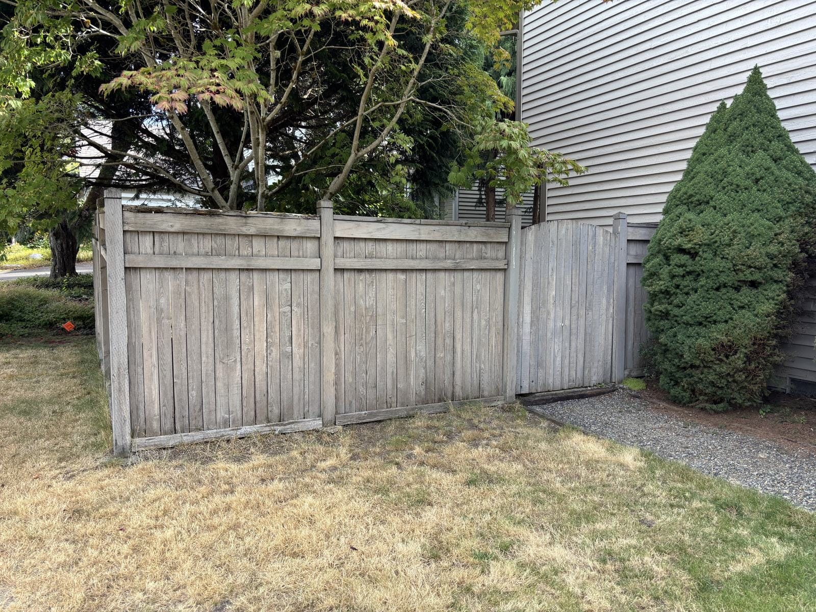 Wide view of weathered fence before demolition in Redmond WA