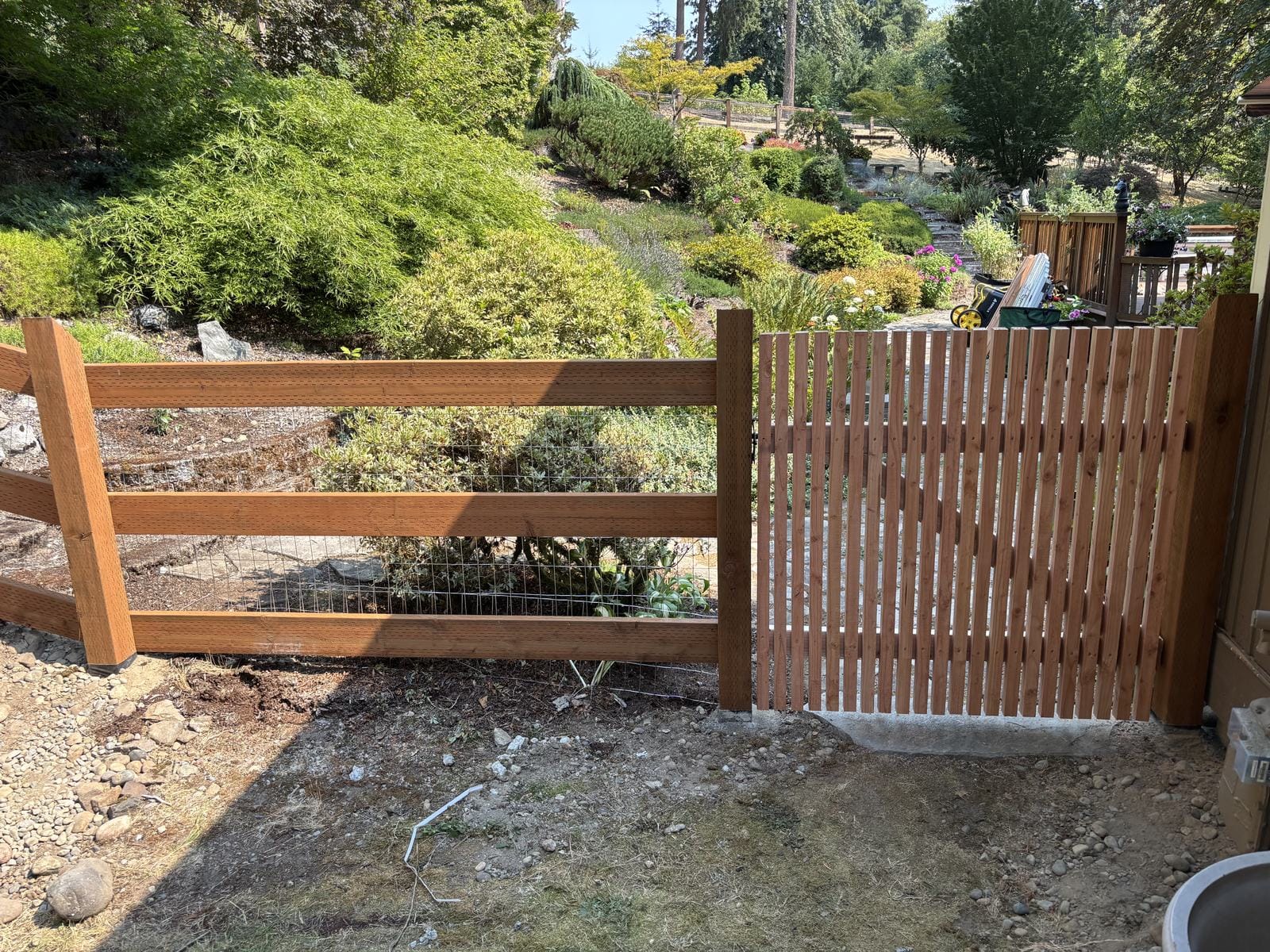 Custom cedar gate connected to ranch and hog wire fencing in Sammamish