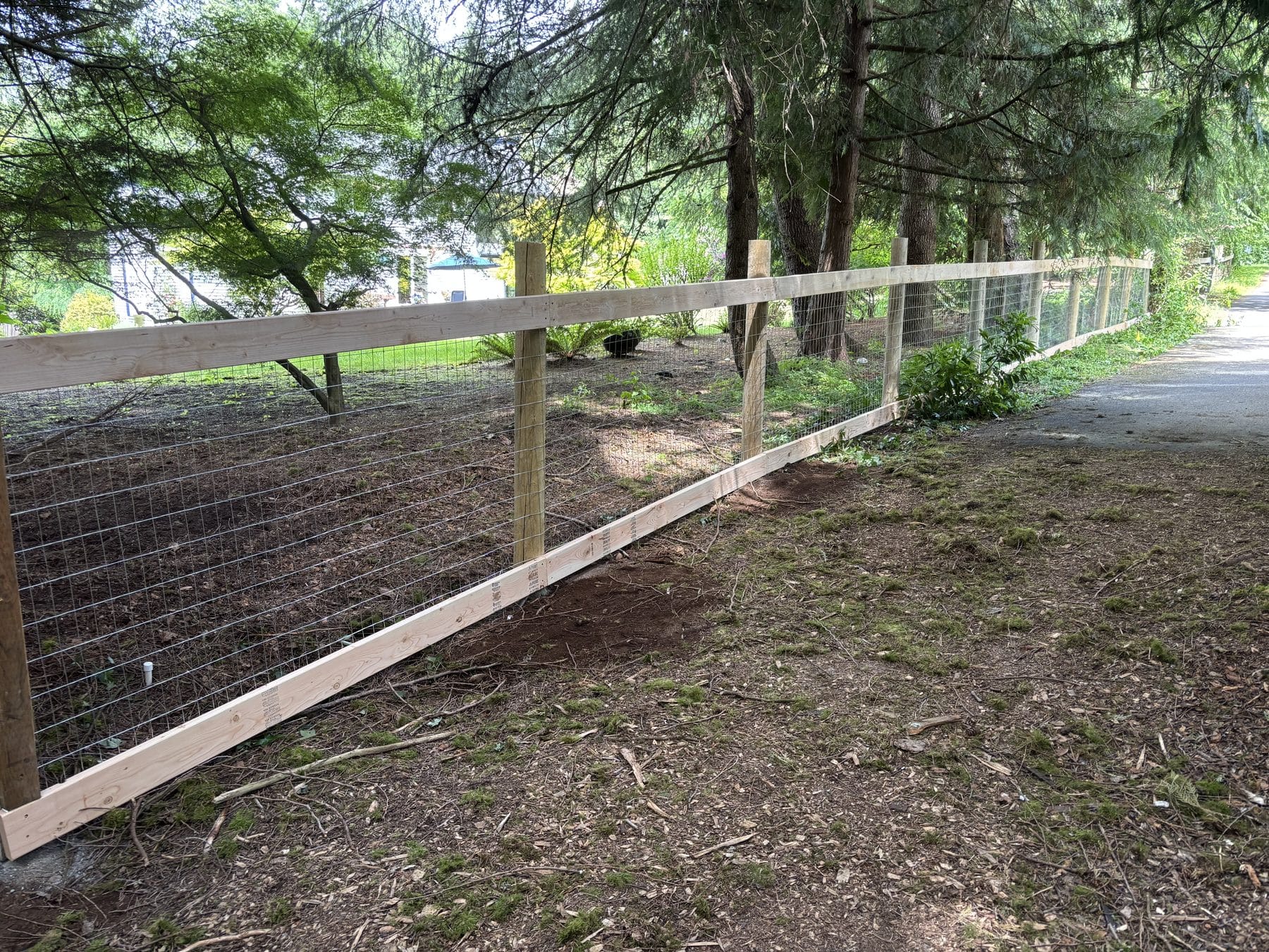 Completed 70 foot hog wire fence with round posts in Woodinville WA